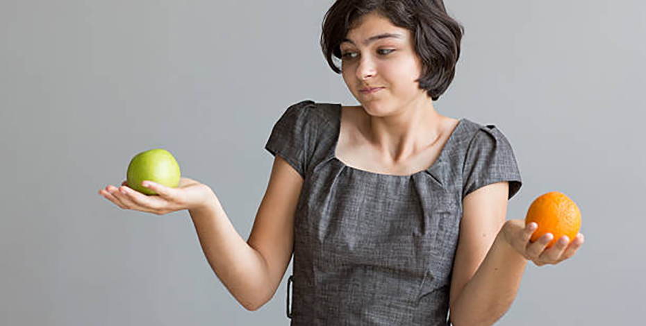 person holding an apple and an orange 